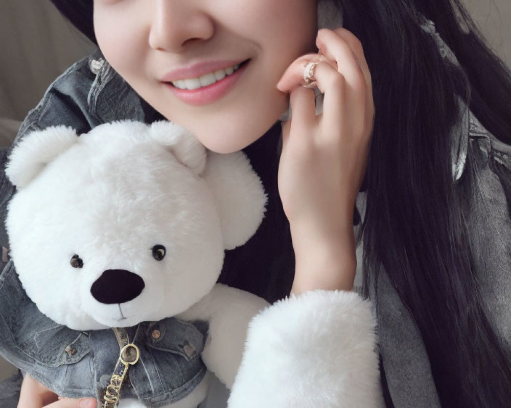 Smiling person in denim jacket with teddy bear and earmuffs