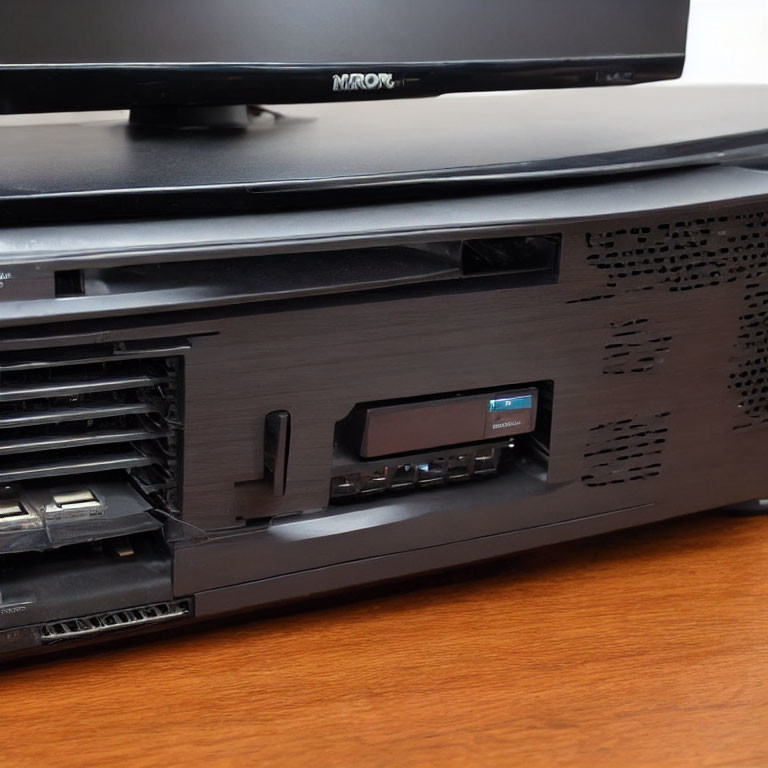 Modern cable TV set-top box with card slot and ports on wooden surface.