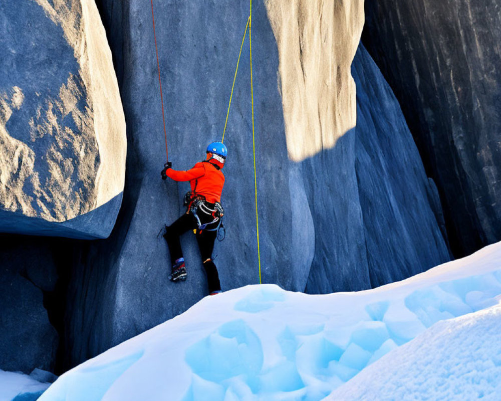 Climber in Orange Helmet Ascends Icy Cliff with Ice Axes