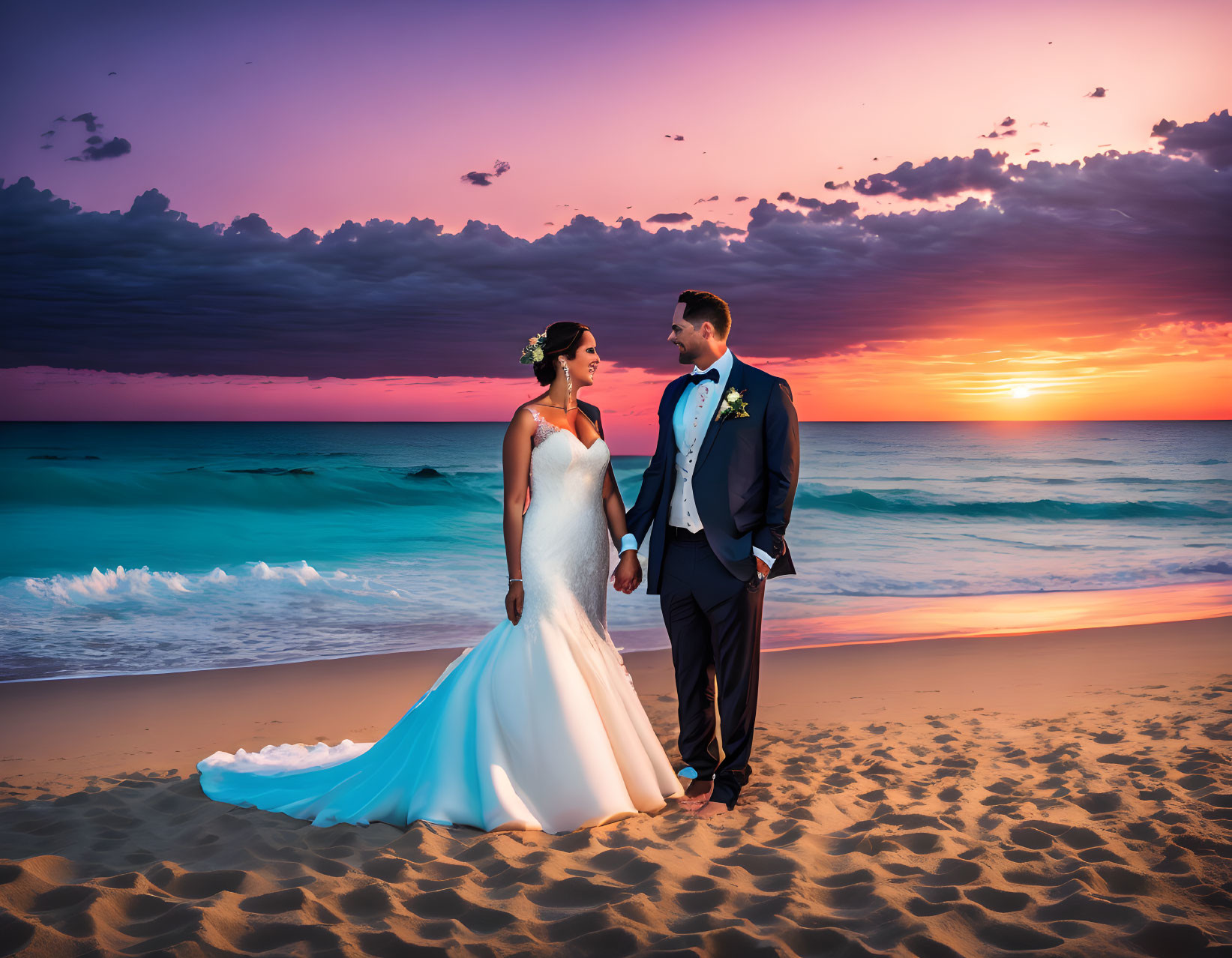 Bride and groom holding hands at sunset