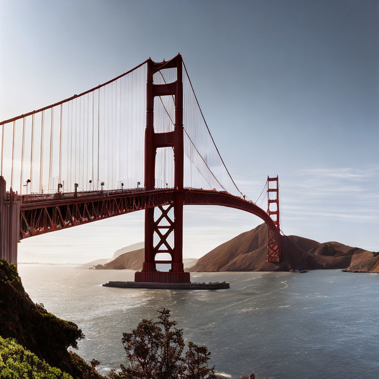 Iconic Golden Gate Bridge Over Blue Bay with Cars, Clear Sky, and Hills