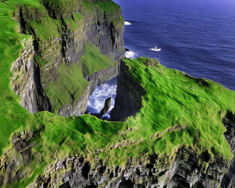 Scenic view of green cliffs, ocean, building, boat, and clear skies