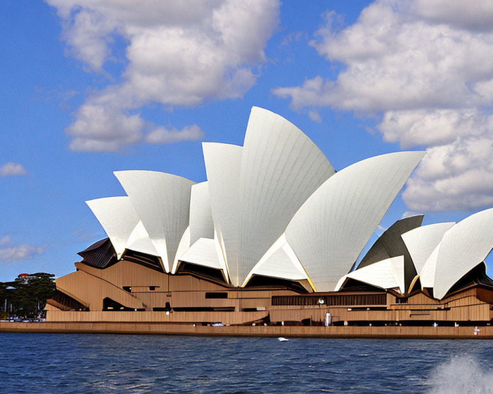 Iconic Sydney Opera House with sail-like design against blue sky.