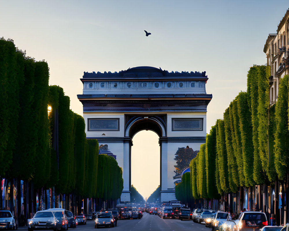 Iconic Arc de Triomphe in Paris at dusk with traffic and trees