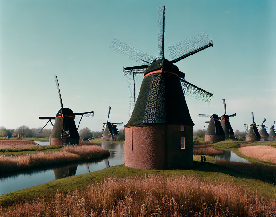 Scenic Dutch windmills by waterway under clear skies