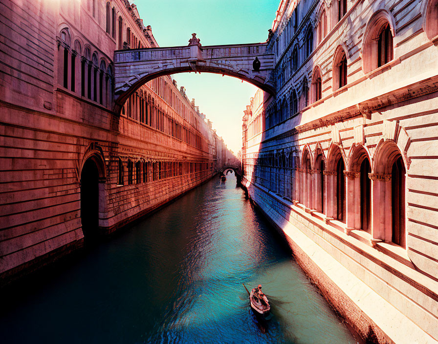 Sunlit Bridge of Sighs in Venice with gondola and historic buildings.