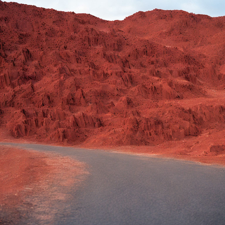 Curving road with red rocky terrain resembling Martian landscape