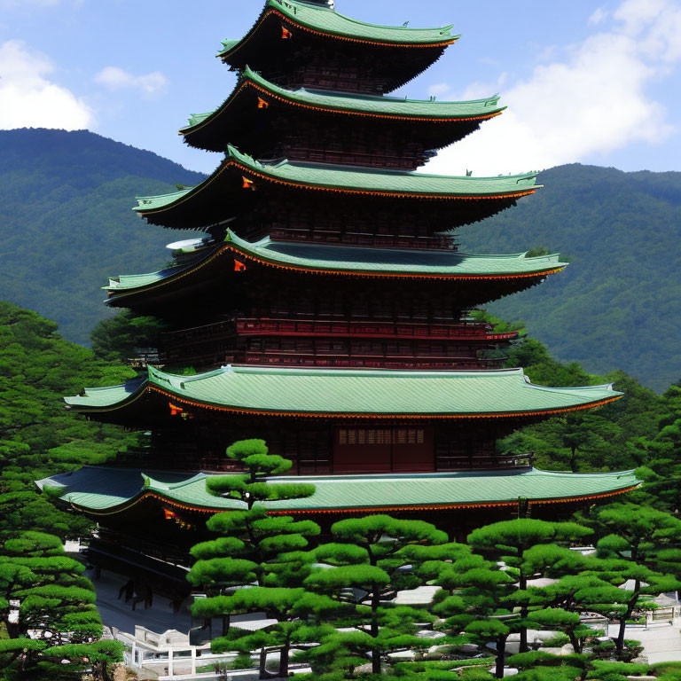 Traditional Japanese Pagoda Surrounded by Green Trees and Mountains
