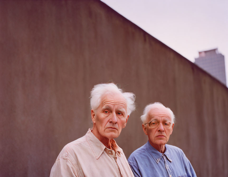 Elderly Men Standing in Front of Plain Wall with Dusky Sky