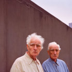 Elderly Men Standing in Front of Plain Wall with Dusky Sky