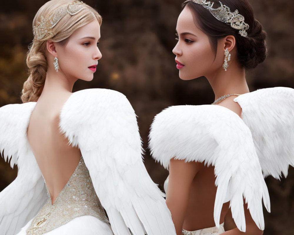Two women with angel wings and headpieces in elegant contrast on dark background
