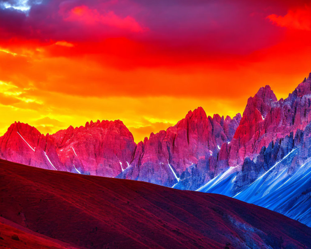 Colorful sunset over mountain peaks with rolling hill silhouette