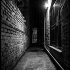 Dimly Lit Alley Between Tall Buildings at Night