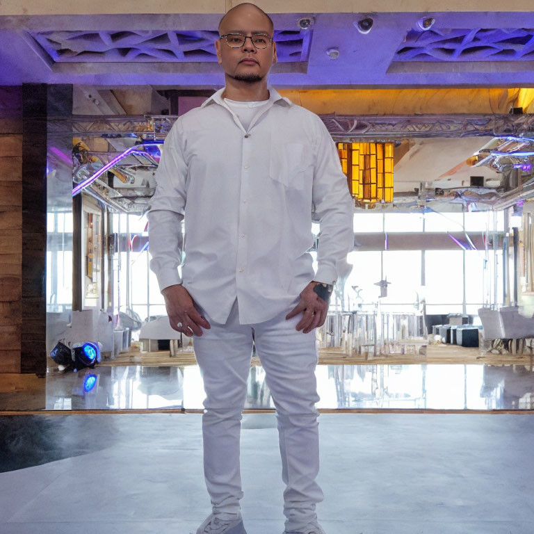 Confident man in white shirt and pants in modern interior.
