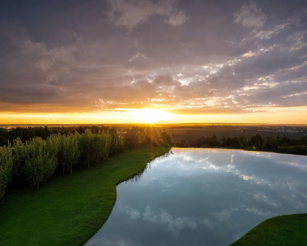 Tranquil sunset scene with radiant clouds reflected on a still pond