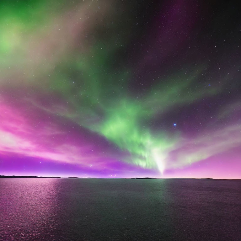 Colorful aurora borealis over dark ocean horizon at night