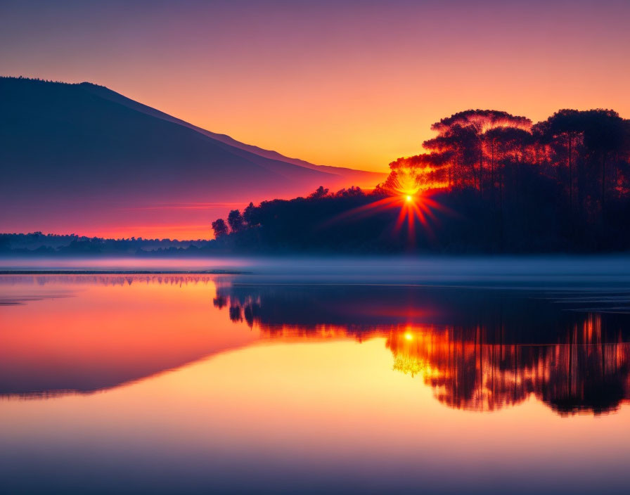 Tranquil lake sunrise with tree and mountain reflections in orange and purple hues