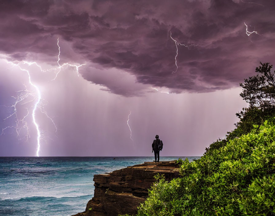 Person on Cliff During Thunderstorm with Lightning Strikes