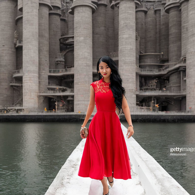 Woman in Red Dress on White Walkway by Water with Cylindrical Structures