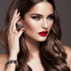 Elegant woman with bold makeup and jewelry against gray backdrop