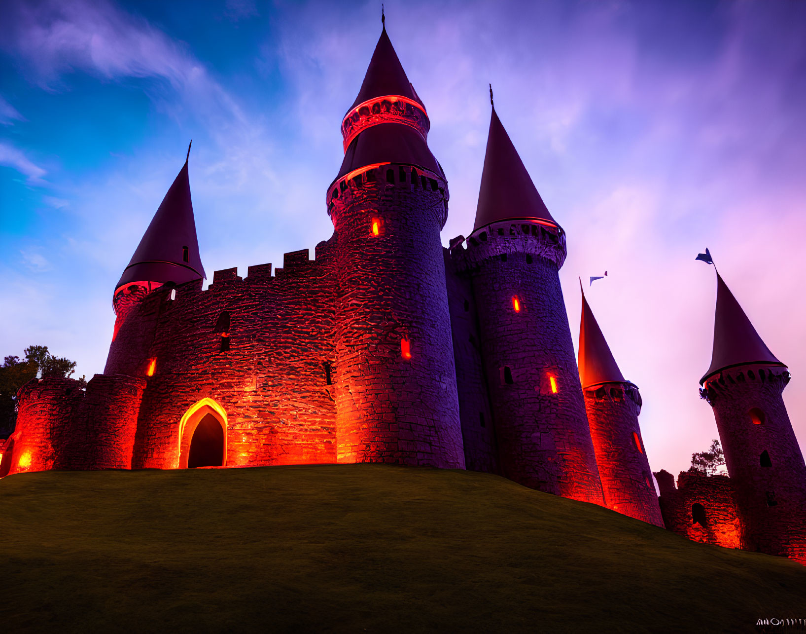 Majestic castle with colorful spires under red-lit twilight sky