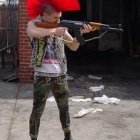 Punk woman with red mohawk fires assault rifles in explosive scene