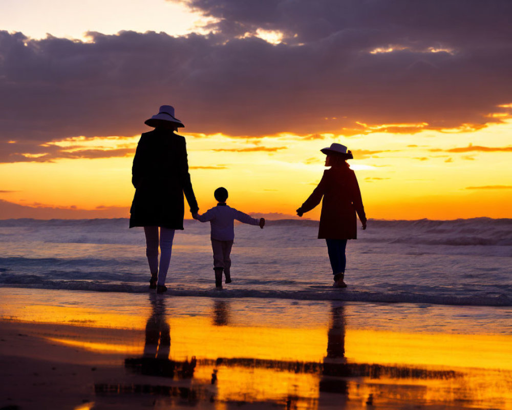 Family walking on beach at sunset with vivid orange skies and silhouettes.