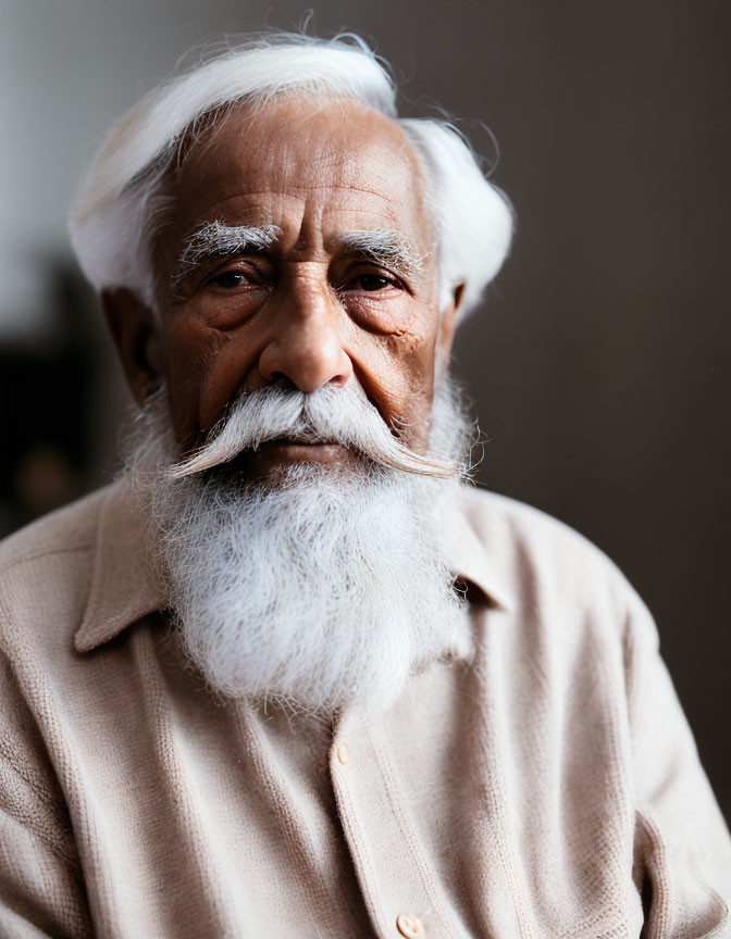 Elderly man with white beard and mustache in button-up shirt