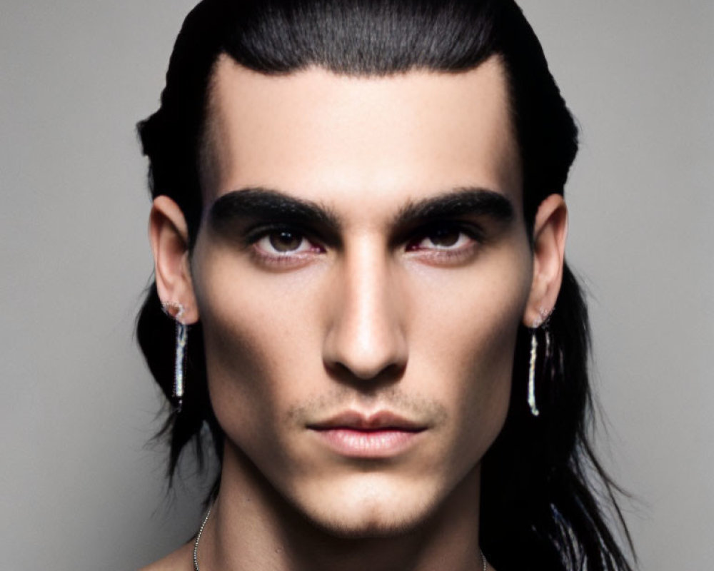Man with Slicked-Back Hair and Earrings in Neutral Expression