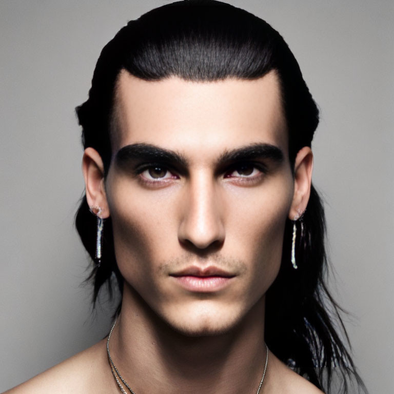 Man with Slicked-Back Hair and Earrings in Neutral Expression