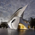 Curved modern architecture design with large windows in tranquil twilight landscape