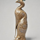 Golden Bird Sculpture with Gemstone on Grey Background