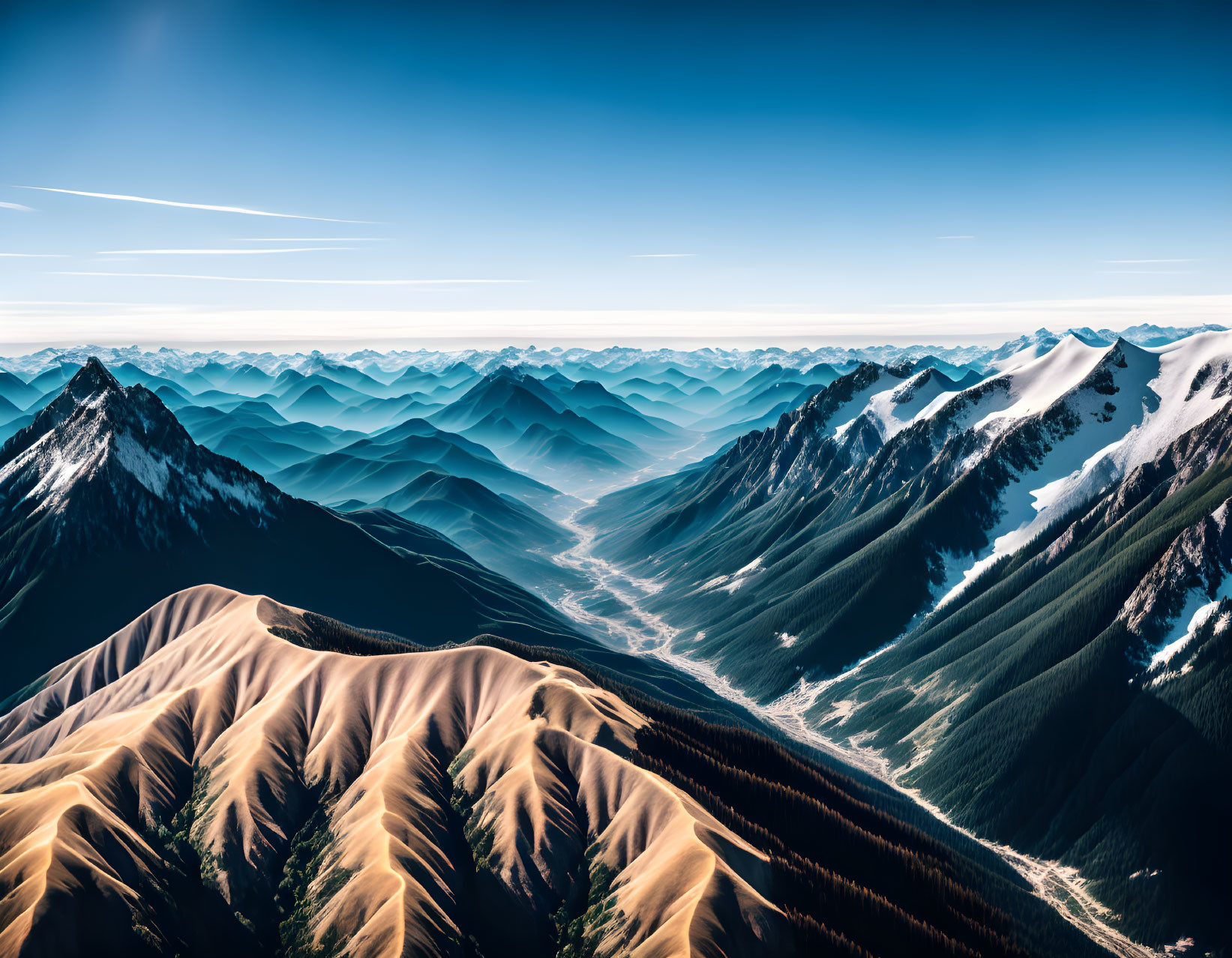 Snowy Peaks and Shadowy Valleys: Aerial View of Layered Mountain Ranges