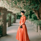 Elegant Woman in Orange Dress Among Blooming Trees