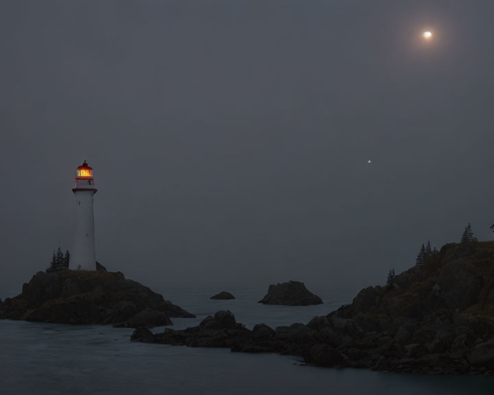 Misty evening coastal scene with glowing lighthouse and moon