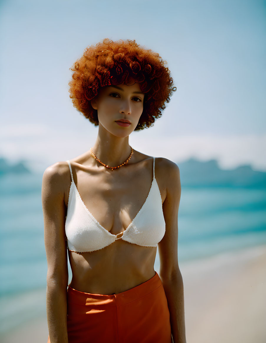 Curly Red-Haired Woman in White Bikini Top on Beach