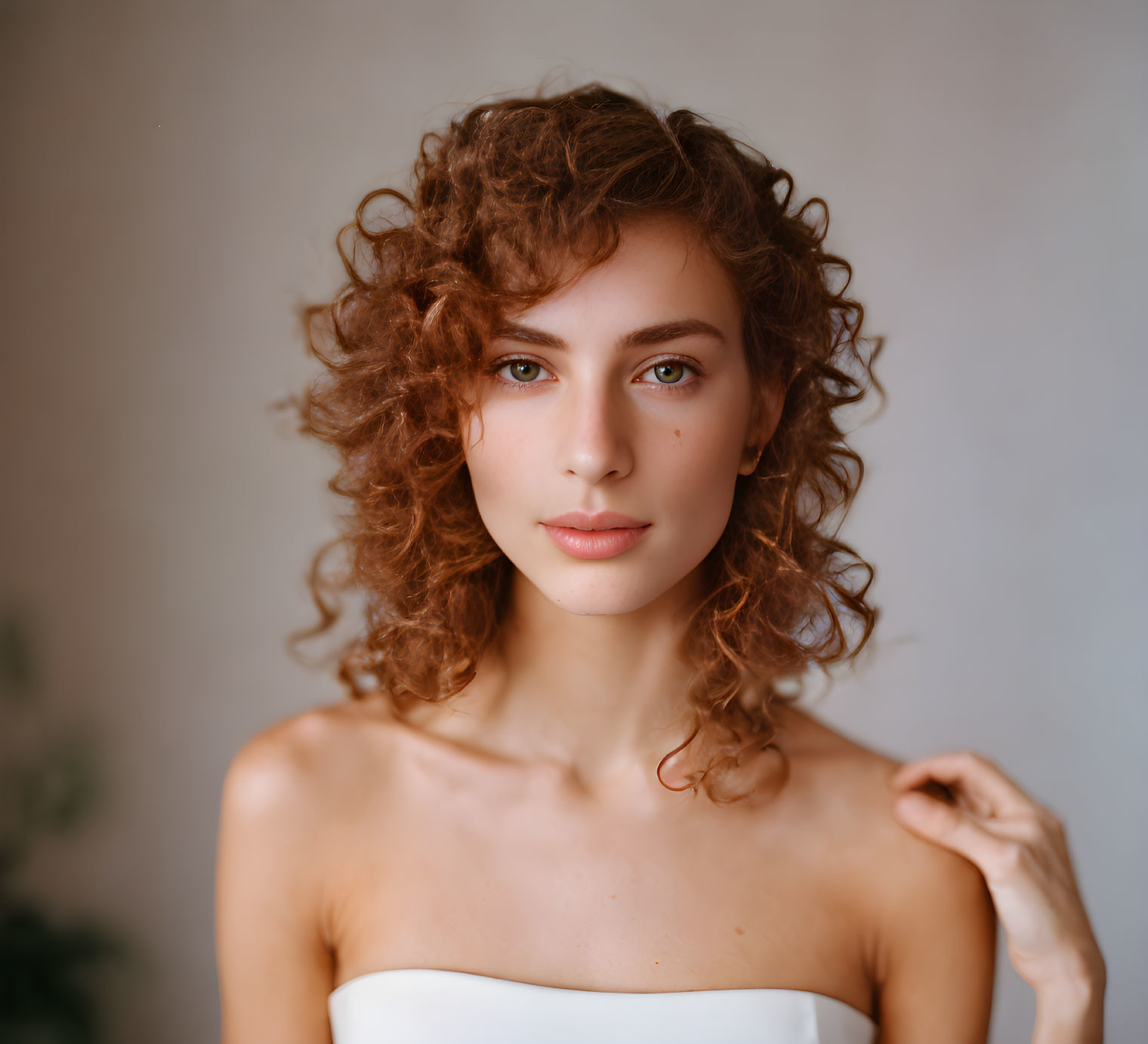 Curly-Haired Youth with Natural Makeup on Neutral Background