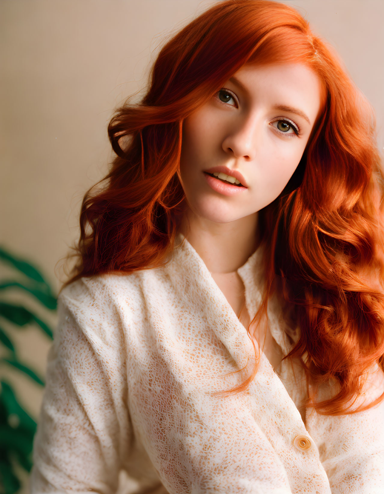 Portrait of person with long red hair and white shirt on neutral background