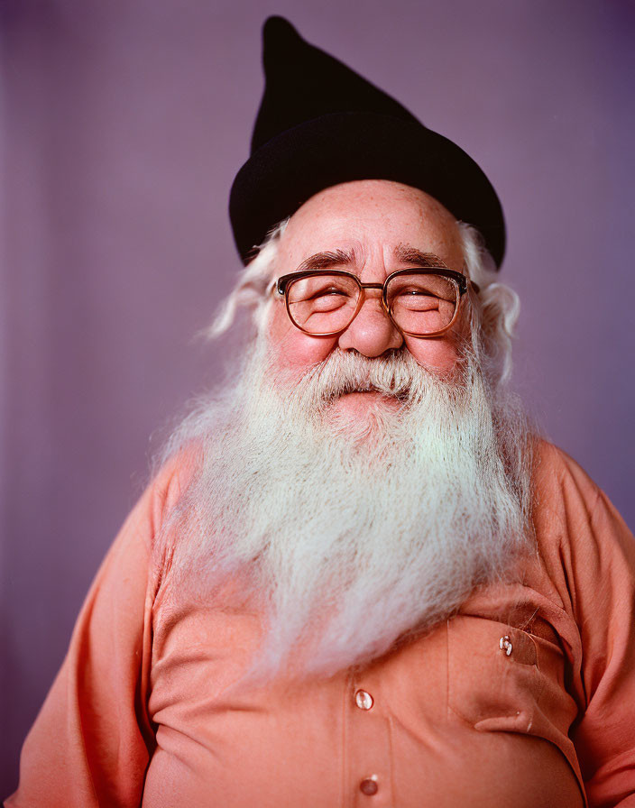 Elderly Man with White Beard and Glasses in Black Beret and Orange Shirt on Purple Background