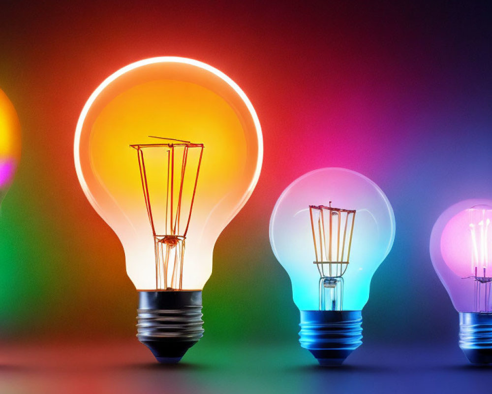 Four colorful glowing light bulbs on dark background