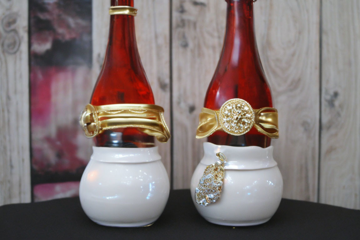 Decorative perfume bottles: white bases, red tops, one with gold ribbon, one with jeweled