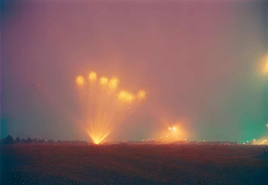 Heart-shaped fireworks illuminate misty night sky with distant observers.