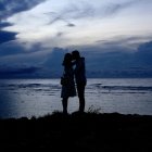 Romantic silhouette of couple against ornate blue and gold backdrop