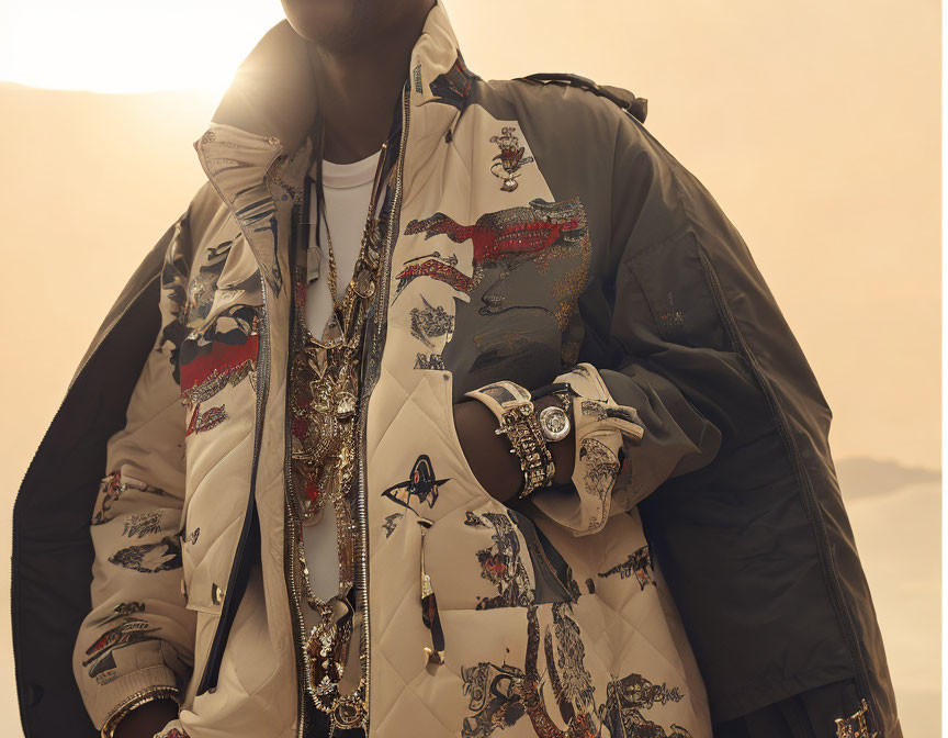 Stylish person in oversized jacket with gold chains and flashy watch on warm background