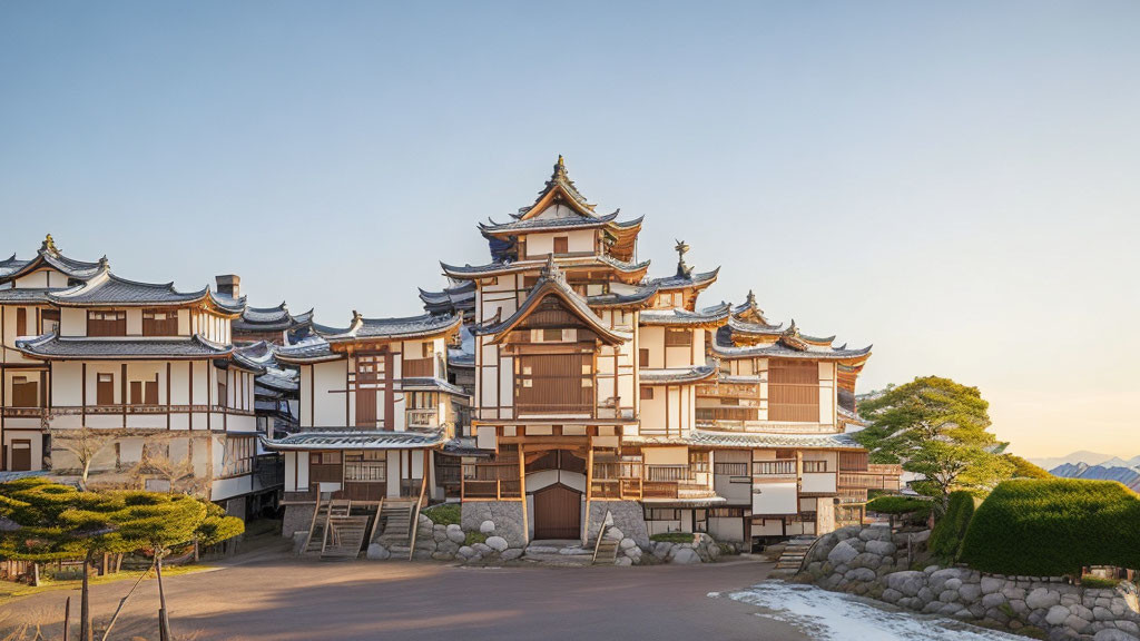 Japanese castle with multi-tiered roofs and white walls against mountain backdrop