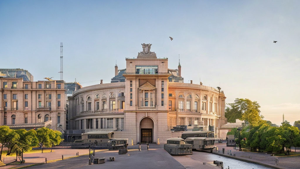 Neoclassical building with archway and sculptures at sunrise with military vehicles.