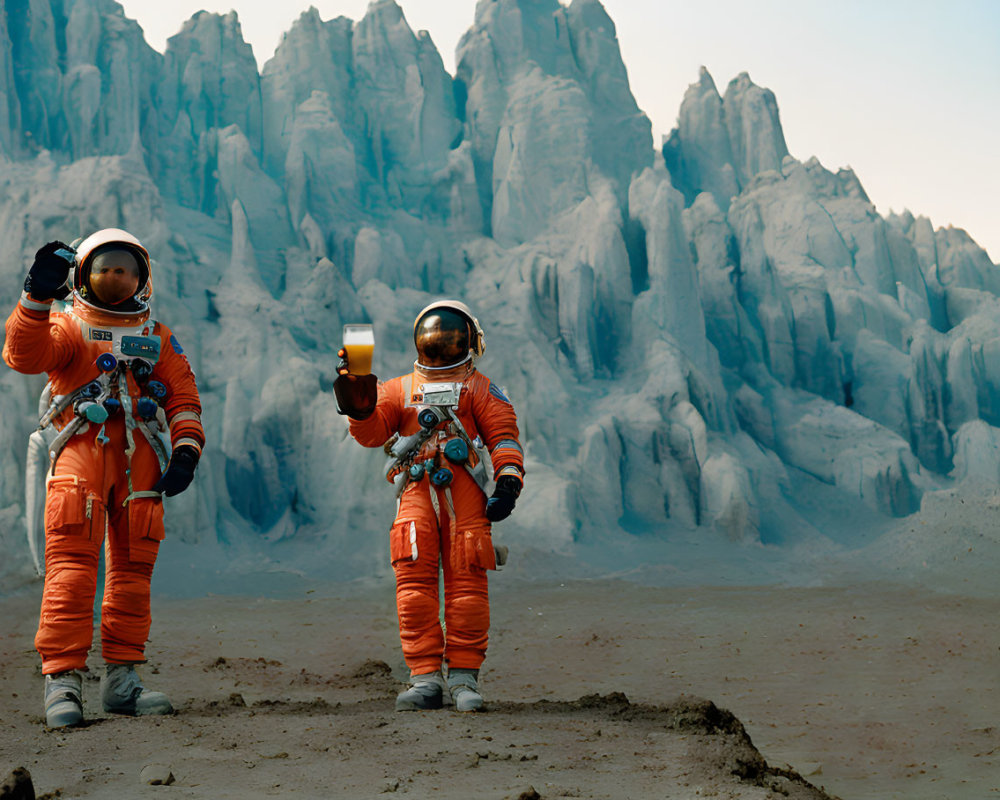 Two astronauts in orange space suits on rocky terrain with flag and mountains.