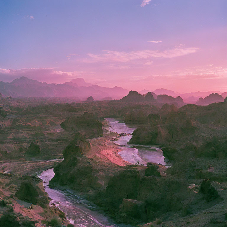 Serene twilight over winding river and rugged mountains in soft pink and purple sky