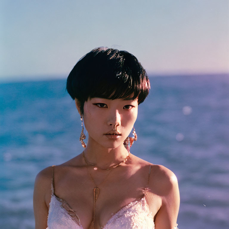 Short-haired woman by the sea in sunlight.