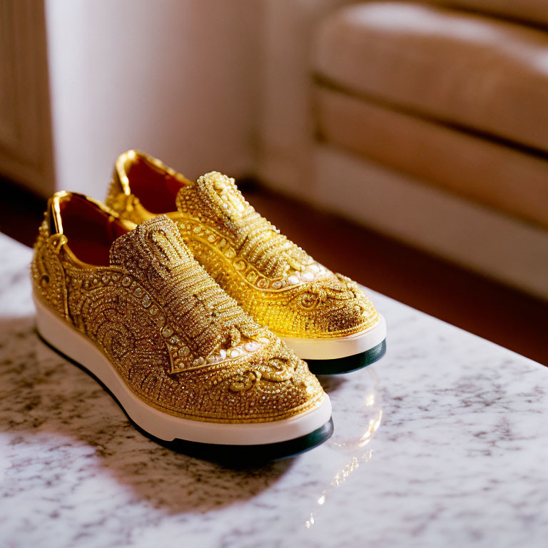 Golden Bejeweled Slip-On Sneakers on Marble Surface